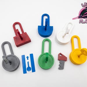 May include: A selection of brightly coloured 3D-printed padlocks and keys in red, blue, white, green, grey, and yellow. A blue and white card with a key graphic is also present. The Laser Platypus logo is in the upper right corner.