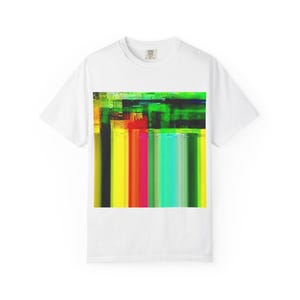 Puede incluir: Una camiseta blanca de manga corta con un estampado gráfico rectangular central. El diseño consta de rayas verticales en tonos vibrantes de amarillo, naranja, rojo, turquesa y verde, con un patrón oscuro, texturizado y tipo glitch en la parte superior.