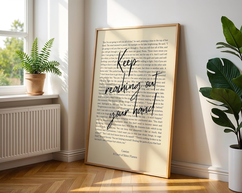 A Court of Silver Flames Print: Nesta & Cassian Quote (Digital Download) Chapter 50 Quote
A framed art print with a cream-colored background. The print features a quote in black cursive that reads 'Keep reaching out your hand.' The text is layered over a smaller font of a novel. The bottom of the print reads 'Cassian, A Court of Silver Flames.'
