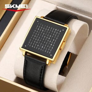 May include: A square-faced SKMEI watch with a black face and gold-colored frame. The watch face displays the time using words. The watch has a black leather band and is presented in a white box.