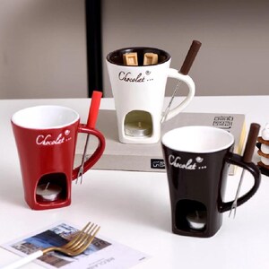 Può includere: Tre tazze in ceramica con un pentolino per fondue incorporato e un manico. Le tazze sono bianche, rosse e nere con la scritta "Chocolat..." su di esse. Ogni tazza ha un piccolo portacandele e una forchetta di metallo.