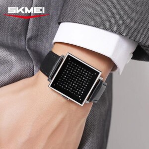 May include: A black digital watch with a square face and a black leather band is displayed. The watch face has a grid of letters. The watch is branded with the word "SKMEI" in white letters.