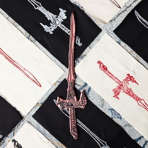 May include: A collection of fabric squares with different colored and stylized sword designs printed on them. The swords are all in a similar style, with intricate details and a pointed tip. The fabric squares are arranged in a grid pattern, with the swords pointing in different directions.