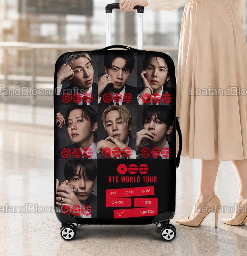May include: Black rolling suitcase featuring a collage of portraits of a musical group. The suitcase has the text "BTS WORLD TOUR" in red and white. The suitcase is being held by a person.