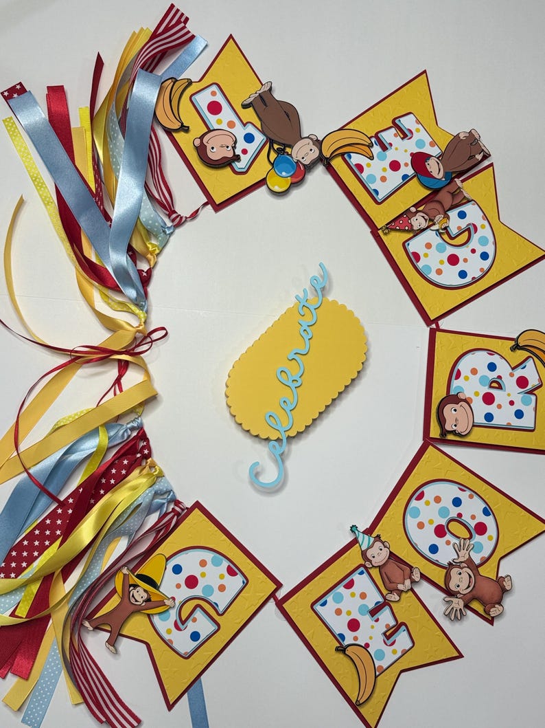 May include: A colorful birthday banner with yellow pennants, each displaying a number and a cartoon monkey. The banner includes the word "Celebrate" and is adorned with ribbons in various colors, including red, blue, and yellow. Bananas are also featured.