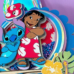 Może przedstawiać: Wielowarstwowa, kolorowa dekoracja na tort urodzinowy z postaciami Lilo i Stitch. Projekt zawiera cyfrę 8, czerwono-białe wzorzyste tło i słowo "enilss". Elementy dekoracyjne obejmują kwiaty i tropikalne liście.