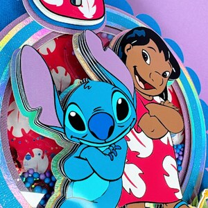 Może przedstawiać: Wielowarstwowa dekoracja urodzinowa z postaciami Stitcha i Lilo z filmu animowanego Lilo & Stitch. Numer 8 jest wyraźnie widoczny, wraz z tekstem "Endless". Projekt łączy żywe kolory i zabawną estetykę.