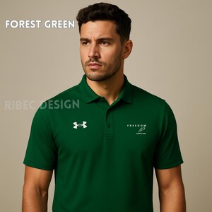 Op de afbeelding: Bospolo shirt met een wit logo en het woord "FREEDOM" op de voorkant. De shirt heeft een kraag en korte mouwen. De tekst "FOREST GREEN" staat bovenaan.