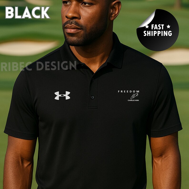 Op de afbeelding: Zwarte poloshirt met wit logo en tekst. Het shirt heeft de tekst "FREEDOM" en een handtekening. Het woord "BLACK" staat linksboven. Het shirt heeft korte mouwen.