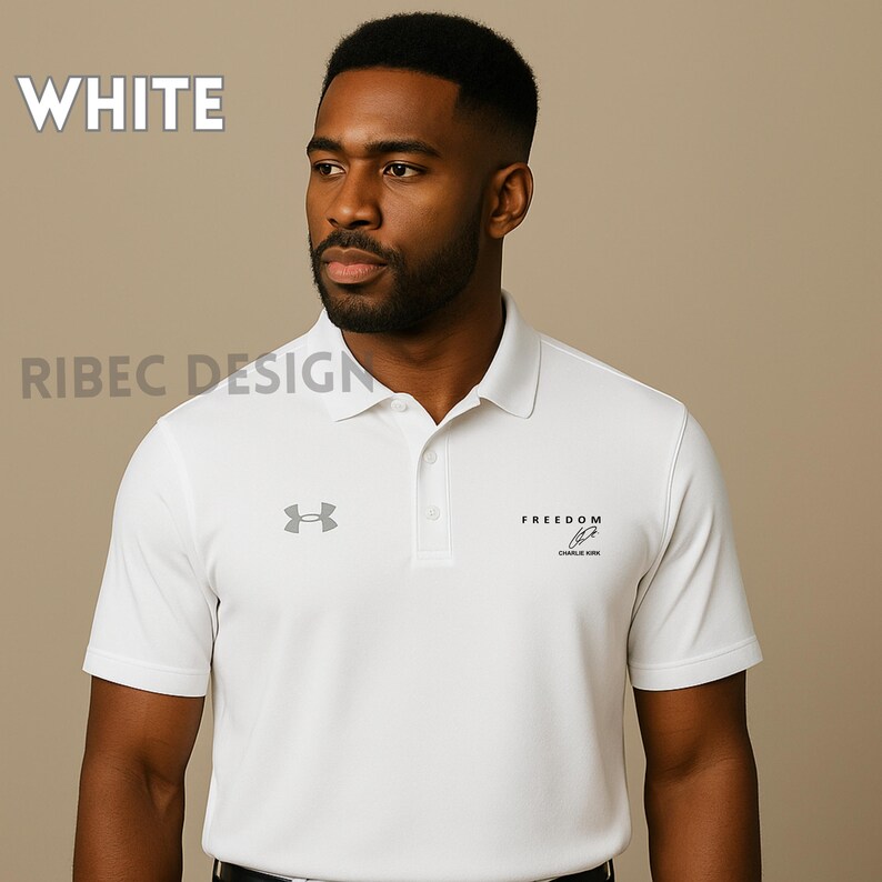 Op de afbeelding: Witte poloshirt met een knoopsluiting met drie knopen, korte mouwen en een kraag. Het shirt heeft de tekst "FREEDOM" en een logo op de borst. Het woord "WHITE" wordt linksboven weergegeven.