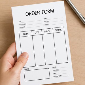 Puede incluir: Un formulario de pedido blanco con el título "ORDER FORM" en texto negro. El formulario incluye campos para información del cliente, detalles del artículo y totales. Un bolígrafo plateado descansa sobre la superficie de madera.