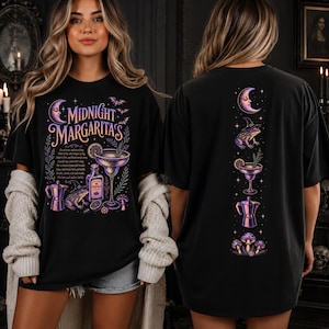 May include: A black t-shirt featuring a graphic print with the text Midnight Margaritas, a cocktail glass, a tequila bottle, a frog wearing a witch hat, a moka pot, and mushrooms. The back of the shirt displays a vertical column of these icons.