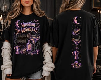 Könnte beinhalten: Ein schwarzes T-Shirt mit einem Grafikdruck, der den Text Midnight Margaritas, ein Cocktailglas, eine Tequilaflasche, einen Frosch mit Hexenhut, eine Mokkakanne und Pilze zeigt. Auf der Rückseite ist eine vertikale Spalte dieser Symbole abgebildet.