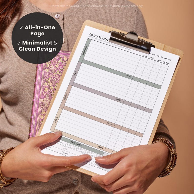 Lifestyle image of a woman holding a printed daily food log, highlighting how it can help organize daily meal, calorie, macro and fitness tracking. With text overlays: “*check mark* all-in-one page” “*check mark* minimalist & clean design”