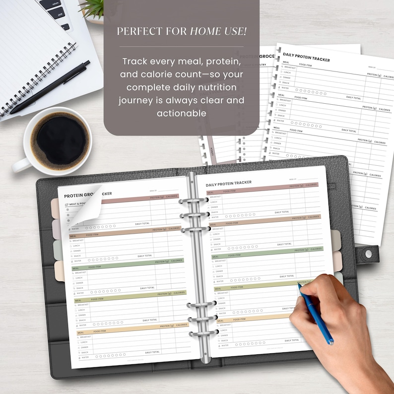 Puede incluir: Un archivador de cuero negro abierto en una p&aacute;gina de "Daily Protein Tracker", con un bol&iacute;grafo en la mano escribiendo en la p&aacute;gina. El texto "PERFECT FOR HOME USE!" est&aacute; en la parte superior, con el texto "Track every meal, protein, and calorie count" debajo.