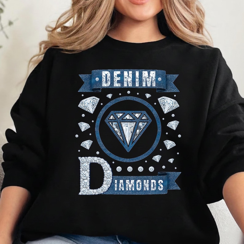 May include: Black sweatshirt with a blue graphic that reads "DENIM DIAMONDS." The design features a large diamond in a circle, surrounded by smaller diamonds. The word "DENIM" is on a banner above the diamond, and "DIAMONDS" is below.