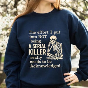 May include: Navy blue sweatshirt with the text "The effort I put into NOT being A SERIAL KILLER really needs to be Acknowledged." A skeleton graphic is also featured on the sweatshirt.