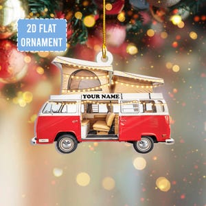 May include: A red and white camper van ornament with a pop-up tent on top. The ornament has the text "YOUR NAME" and "2D FLAT ORNAMENT". The camper van has an open door, revealing the interior.