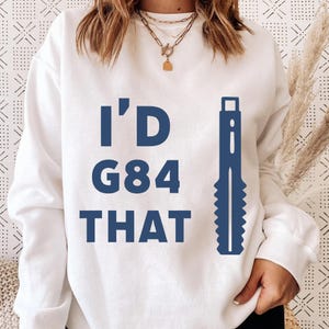 May include: White sweatshirt with the text "I'D G84 THAT" in navy blue. A navy blue graphic of a tool is on the right side of the text. The sweatshirt is a casual style.