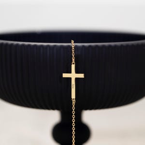 Puede incluir: Una taza de cerámica blanca con asa negra y el texto "But First, Coffee" en negrita negra. La taza se encuentra sobre un fondo neutro, resaltando su diseño sencillo.