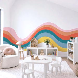 May include: A wall mural featuring a series of wavy, horizontal stripes in shades of pink, orange, teal, blue, and yellow. The design spans the width of the wall, creating a colorful, curved pattern that serves as a backdrop for a room.