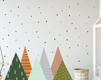 May include: A wall decal featuring a mountain range design in shades of green, orange, gray, and tan. The mountains have various patterns, and there are small, scattered dots above. The design is suitable for a nursery or children's room.