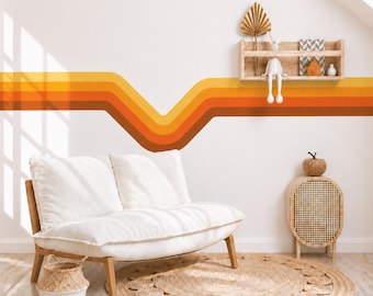 Pode incluir: Um sofá de dois lugares branco com almofadas macias está posicionado diante de uma parede com uma faixa horizontal em ziguezague em tons de amarelo, laranja e marrom. Uma prateleira de madeira contém um coelho branco e um tapete redondo trançado.