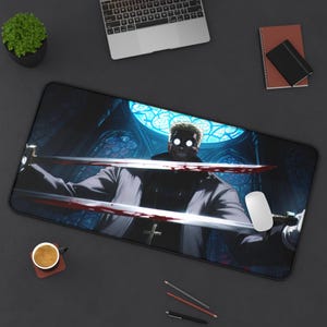 May include: A black rectangular desk mat featuring a digital illustration of a character holding two swords with blood on them. The character has glowing eyes and a sinister smile. A cross is visible on the character's chest.