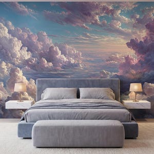 May include: A bedroom with a large mural of a cloudy sky. The bed is gray with a matching bench at the foot. Two white bedside tables each hold a lamp. The room has a large window and a light-colored rug.