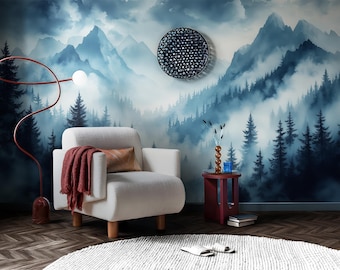 May include: A cozy living room scene featuring a white armchair with a red throw blanket and a decorative pillow. A red side table holds a vase and books. The backdrop is a mural of a misty mountain forest. A modern floor lamp and a round rug complete the decor.