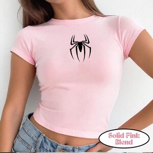K&ouml;nnte beinhalten: Hellrosa kurz&auml;rmeliges T-Shirt mit einem schwarzen Spinnen-Motiv. Das Shirt hat einen Rundhalsausschnitt und ist aus weichem Material. Der Text "Solid Pink Blend" befindet sich in einem wei&szlig;en Oval.