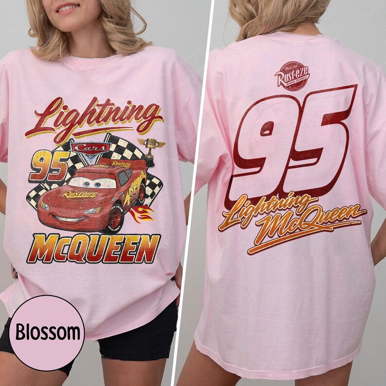 Puede incluir: Camiseta rosa claro con un dise&ntilde;o de Rayo McQueen de la pel&iacute;cula Cars. El dise&ntilde;o frontal incluye el texto "Lightning McQueen" y "95". La parte trasera de la camiseta muestra un gran "95" y "Lightning McQueen" en rojo y dorado.