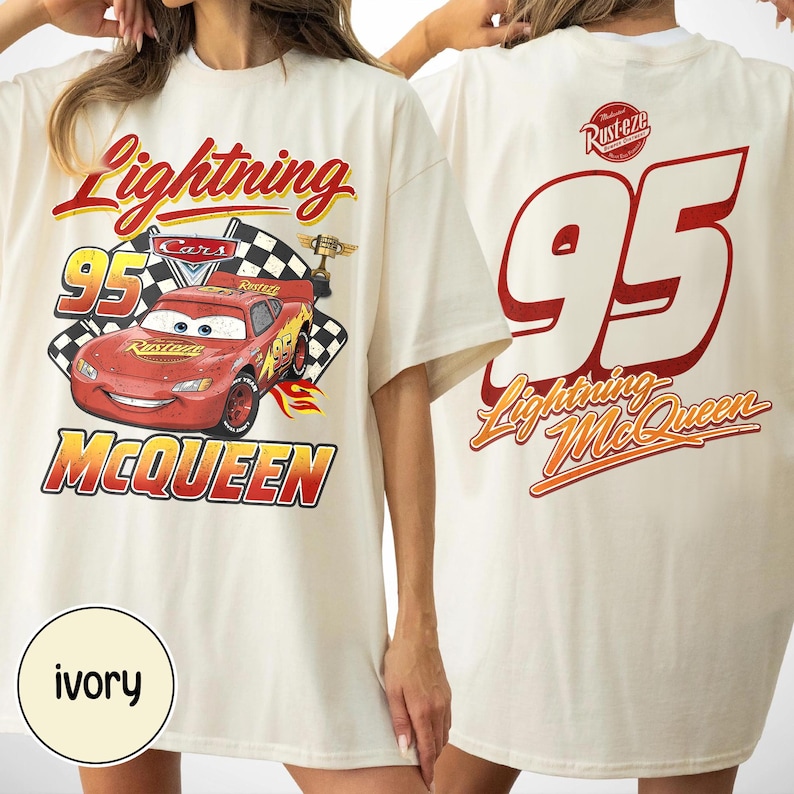 May include: Ivory t-shirt featuring Lightning McQueen from the Cars film. The front graphic includes the number 95, a chequered flag, and the words "Lightning McQueen" in red and yellow. The back displays the number 95 and "Lightning McQueen" in red and orange.