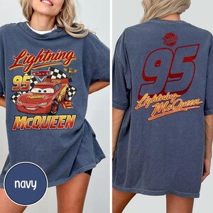 Puede incluir: Camiseta azul marino con Lightning McQueen de la pel&iacute;cula Cars. El gr&aacute;fico frontal muestra a McQueen con el n&uacute;mero 95 y el texto "Lightning McQueen". La parte trasera de la camiseta tambi&eacute;n tiene el n&uacute;mero 95 y "Lightning McQueen" en rojo y naranja.