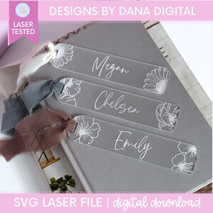 Clear acrylic bookmarks with white floral designs and personalized names: Megan, Chelsea, and Emily. Each bookmark has a ribbon attached. The text "DESIGNS BY DANA DIGITAL" and "SVG LASER FILE | digital download" are also visible.
Birth Month Flower Bookmark Svg File Digital Download Laser Cut Design Acrylic Bookmark Template Personalized Gift For Mom Mothers Day Present Custom Bridesmaid Keepsake Gift Grandma Birthday Gift Floral Design Svg Laser Cutting File