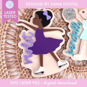Puede incluir: Figura de madera cortada con láser de una bailarina con un vestido morado y patines blancos. La figura tiene un moño negro y un lazo morado. El nombre "Violet" está escrito en escritura morada. También se ve el texto "DESIGNS BY DANA DIGITAL" y "LASER TESTED".