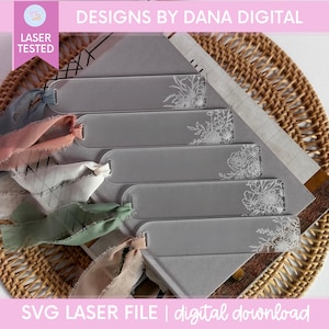 Op de afbeelding: Transparante acryl bladwijzers met bloemmotieven en kleurrijke linten. De bladwijzers zijn laser getest en voorzien van de tekst "DESIGNS BY DANA DIGITAL" en "SVG LASER FILE | digital download".