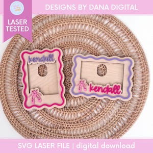 May include: Two wooden frames with scalloped edges, one pink and one purple, each with a cutout and the name "Kendall". Pink ballet shoes are on each frame. The text "DESIGNS BY DANA DIGITAL" and "LASER TESTED" are also visible.