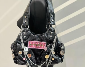 May include: Black faux leather handbag with a pink "Howdy Pumpkin" patch, multiple silver buttons, and a silver chain strap with charms.