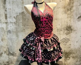 Conjunto elegante de dos piezas estilo gótico suave Y2K: top halter cruzado con estampado de leopardo y corazón rosa, minifalda escalonada de satén con encaje y lunares rosas y negros.