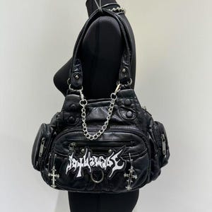 May include: Black faux leather handbag with silver hardware, a chain strap, and a patch that says "31143035".