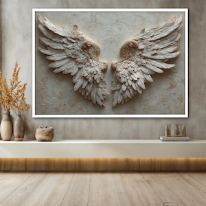 May include: A framed wall art piece featuring a pair of sculpted angel wings. The wings are a light beige color with detailed feather textures. The background has a subtle floral pattern. The artwork is displayed above a white shelf.