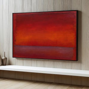 Könnte beinhalten: Abstraktes Gemälde mit einem Farbschema aus Rot, Orange und Lila. Das Gemälde ist in Schwarz gerahmt und hängt an einer Holzwand.