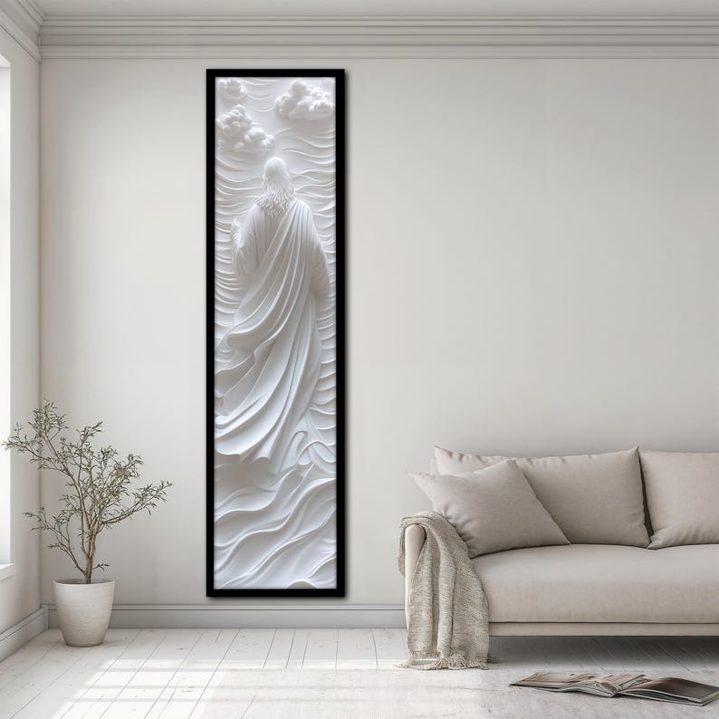 K&ouml;nnte beinhalten: Eine wei&szlig;e 3D-Wandskulptur einer Person in einem flie&szlig;enden Gewand vor einem Hintergrund aus Wolken. Die Skulptur ist schwarz gerahmt und an einer wei&szlig;en Wand montiert.