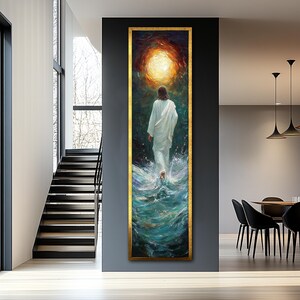 Op de afbeelding: Een schilderij van een man in een witte robe die over water loopt. Het water is diepblauw en groen. De man loopt naar een helder licht in de lucht. Het schilderij is ingelijst in goud.