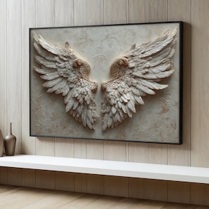 May include: A framed wall art piece featuring a pair of detailed, sculpted angel wings. The wings are a light beige color with intricate feather detailing, set against a textured, off-white background with subtle floral patterns. The frame is black.