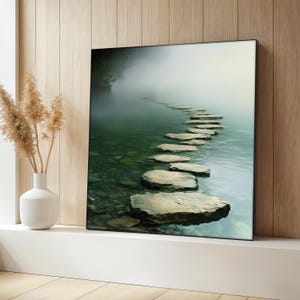 Op de afbeelding: Een mistig, groen meer met een pad van stapstenen dat de diepte in loopt. De stenen zijn lichtbruin en grijs, en het water is helder en kalm.