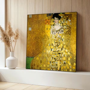 May include: A painting of a woman in a gold dress with a geometric pattern. The background is also gold with a geometric pattern.