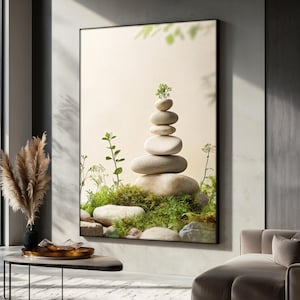 Op de afbeelding: Een print geïnspireerd op een zen-tuin met een stapel gladde, grijze stenen met een kleine groene plant erop. De stenen zijn in een piramidevorm gerangschikt en zijn omgeven door groen mos en gebladerte.