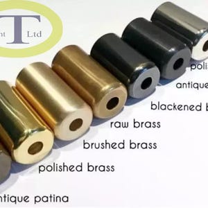 Puede incluir: Una colecci&oacute;n de objetos cil&iacute;ndricos de metal en varios acabados, incluyendo cromo pulido, negro antiguo y lat&oacute;n cepillado. Los objetos est&aacute;n dispuestos en fila, mostrando diferentes colores y texturas. El texto "Light Ltd" es visible.